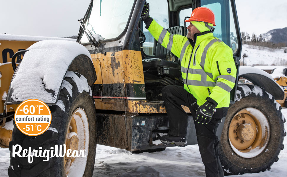Man in the snow outside a tractor wearing the Extreme Hivis Softshell jacket