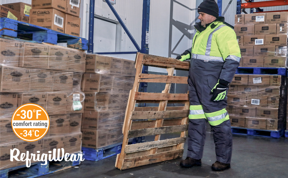 Man in a freezer wearing the Freezer Edge Coveralls carrying a pallet